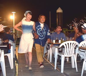 藍染のファッションショーを楽しむ来場者ら＝徳島市の新町川遊覧船乗り場