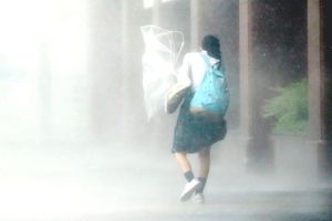 暴風雨の中、登校する学生＝7日、午前8時10分ごろ、徳島駅前