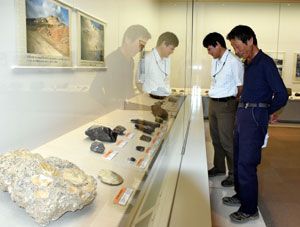 県立博物館に寄贈された１１０点の化石類が初公開された「鎌田誠一　化石コレクション展」。鎌田会長（右）も会場を訪れ、感慨深そうに見入っていた＝同館