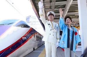 　山形新幹線の開業３０周年を記念した式典で発車の合図をする山形県の吉村美栄子知事（右）ら＝２日午前、ＪＲ山形駅