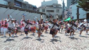 とくしまマルシェの会場で合同演舞する徳島大と四国大の学生＝６月、徳島市の両国橋西公園
