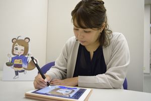 タブレットパソコンで作業をするヤマムラあいさん＝徳島新聞社