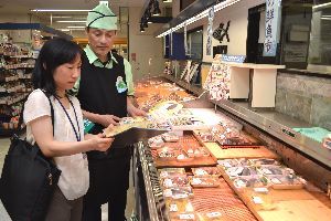 生鮮食品の表示を確かめる県の食品表示Ｇメンの職員（手前）＝そごう徳島店