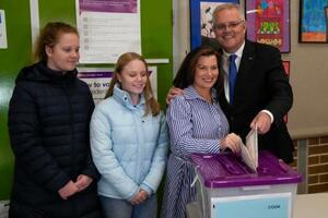 　２１日、オーストラリア・シドニーで、娘２人が見守る中、妻と共に投票するモリソン首相（ＡＰ＝共同）