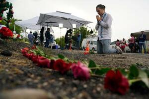　トレーラーの中から移民とみられる多くの遺体が見つかった現場で祈りをささげる人＝２８日、米テキサス州サンアントニオ（ＡＰ＝共同）