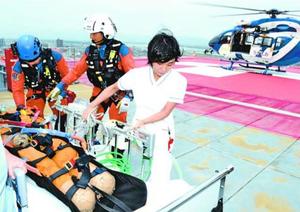 防災ヘリで搬送された負傷者の受け入れ訓練に取り組む看護師(右)=徳島市民病院
