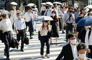 　厳しい暑さの中、マスク姿で歩く人たち＝２７日午前、ＪＲ東京駅前