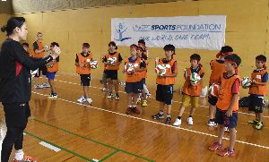 児童にサーブの打ち方を教える櫻井さん（左端）＝海陽町浅川のまぜのおかオートキャンプ場体育館