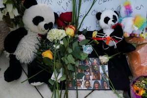 　２７日、米テキサス州ユバルディで、犠牲者を追悼するモニュメントに供えられた花や写真（ロイター＝共同）