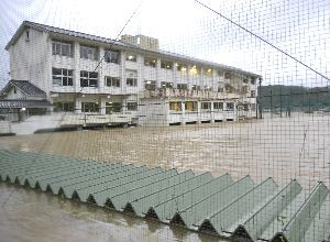 １階部分が約３メートル浸水した加茂谷中の校舎。手前は屋根だけが見えている渡り廊下＝午前５時５０分ごろ、阿南市加茂町