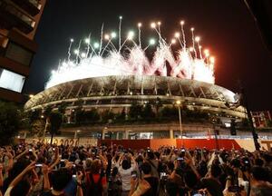 　東京五輪の閉会式で国立競技場から打ち上げられたフィナーレの花火を路上で見上げる大勢の人たち＝２０２１年８月
