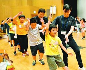 蜂須賀連の連員から踊りの指導を受ける子どもたち=徳島市の阿波おどり会館