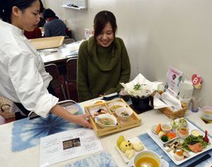上勝町産つまものや旬の野菜を使った料理を提供する生徒（左）＝小松島西高