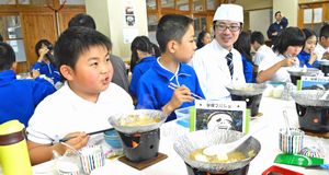 大平副料理長（左から３人目）と一緒に妖怪鍋を味わう児童＝三好市の下名小学校