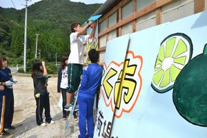 「すきとく市」の集荷場に看板を取り付ける武蔵野大の学生ら＝阿南市大井町