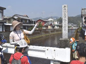 昭和南海地震の最高津波到達水位を示す碑を眺める子どもたち＝海陽町浅川