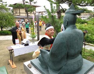 三好長慶の銅像を清める「さかい三好まつり」の参加者ら＝４日、堺市の南宗寺