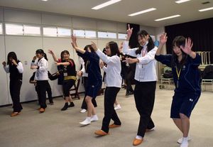 小松島高生（右）から阿波踊りを教わる台湾の女子高生＝小松島市の小松島高校