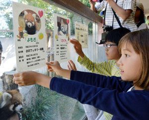 展示施設前に愛称を記したカードを貼り付ける小川さん（手前右）と増田君（中央）＝徳島市のとくしま動物園