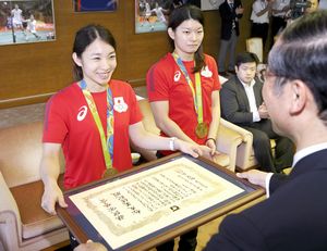 飯泉知事から賞状を受け取り笑顔の松友（左）、高橋（左から２人目）両選手＝県庁