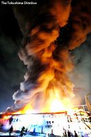 炎と煙が上がる工場＝１６日午後６時４０分、徳島県松茂町満穂