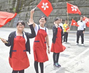 国旗を振って香港の観光客を見送る（左から）李さん、葉さん、蔡さん＝三好市山城町