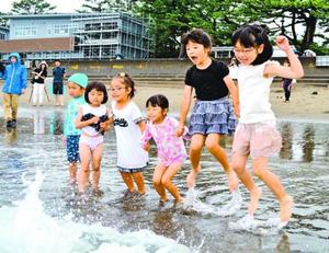 波打ち際で歓声を上げる園児ら=阿南市の北の脇海水浴場