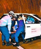 京上トンネルであった訓練で、事故車両から負傷者を救出する消防隊員ら=三好市東祖谷
