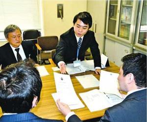 担当職員(奥の2人)から申請方法の説明を受ける長坂さんら=徳島市役所