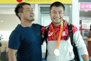 銅メダルを獲得して徳島へ帰ってきた藤本選手（右）。出迎えの稲垣トレーナーと喜び合った＝徳島阿波おどり空港