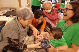 赤ちゃんとの触れ合いを楽しむ高齢者＝藍住町富吉の特別養護老人ホーム・藍寿苑