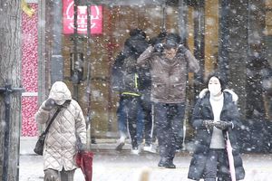 雪の中、足早に歩く人たち＝7日午後2時半ごろ、徳島市の徳島駅前 