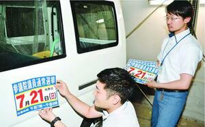 参院選の投票日を知らせるマグネットシールを公用車に付ける担当者=徳島市役所