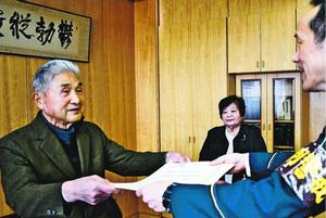 小松島署の田中署長から表彰状を受け取る福山さん(左)と福﨑さん(写真奥)=同署