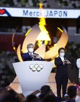 　東京五輪閉会式であいさつし、両手でハートマークをつくるＩＯＣのバッハ会長。右は大会組織委の橋本聖子会長＝２０２１年８月、国立競技場
