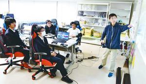 プロジェクターを使って戦略を指導する増田さん(右)らアスリート部門の部員=阿南市の阿南高専