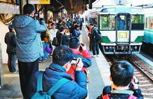大勢の鉄道ファンに見送られ徳島駅からラストランに出発する特急「ホームエクスプレス阿南」=15日午後6時ごろ