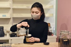 フェアトレードの原料を使ったコーヒーを入れる井坂さん＝徳島市の二軒屋駅構内
