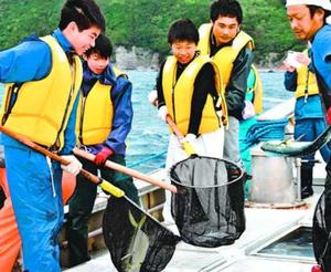 取った魚を漁船の水槽に移す生徒たち=美波町の伊座利漁港沖