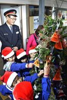 クリスマスツリーに飾り付けをする園児＝三好市池田町の阿波池田駅