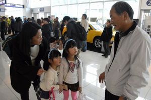 帰省した孫を笑顔で迎える祖父（右）＝徳島阿波おどり空港
