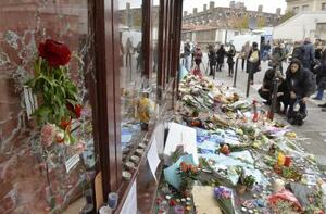 　２０１５年１１月、同時多発テロから週が明けたパリ、銃撃のあったレストランの窓ガラスに残る弾痕と周辺に供えられた花（共同）