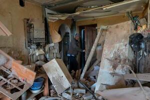 　ウクライナ東部ハリコフ近郊で攻撃を受けた建物と近隣住民＝２７日（ＡＰ＝共同）