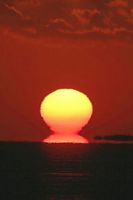 姿を見せた「だるま朝日」。右は浮島現象になった和田島の岬＝５日午前６時５４分、徳島市大原町の大神子海岸から