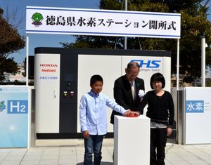 四国で初めて開設された水素ステーションの電源を入れる熊谷副知事（中）＝県庁