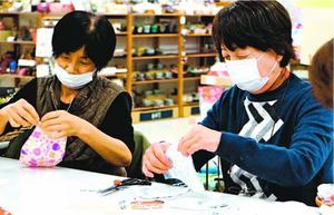 ガーゼとゴムを使って立体型マスクを手作りする参加者=石井町のフジグラン石井