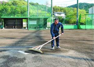 富岡西高野球部の練習グラウンドを整備する小川監督。部活動中止に伴い2カ月近く使われていない=阿南市の同校