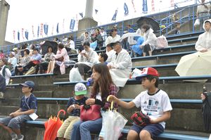 雨の中、好プレーに見入る親子連れら＝徳島市のＪＡバンク徳島スタジアム
