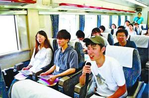 徳島駅から阿波池田駅に向かう列車の中で講師からの質問に答える学生