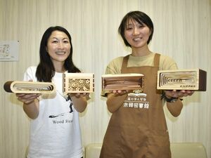 平川さん(左)が開発したウッドスピーカー=那賀町木頭和無田の町木頭図書館